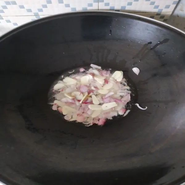 Panaskan minyak goreng, lalu tumis bawang merah dan bawang putih hingga harum