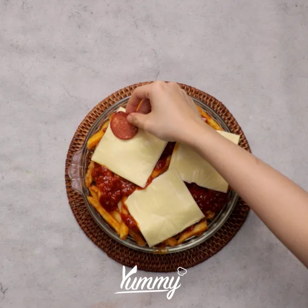 Tambahkan keju lembaran, pepperoni, paprika hijau, dan oregano.