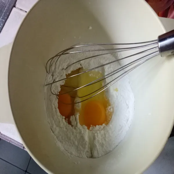 Siapkan wadah lain lalu masukkan telur dan gula halus. Kemudian aduk sampai tercampur rata dan gula larut.