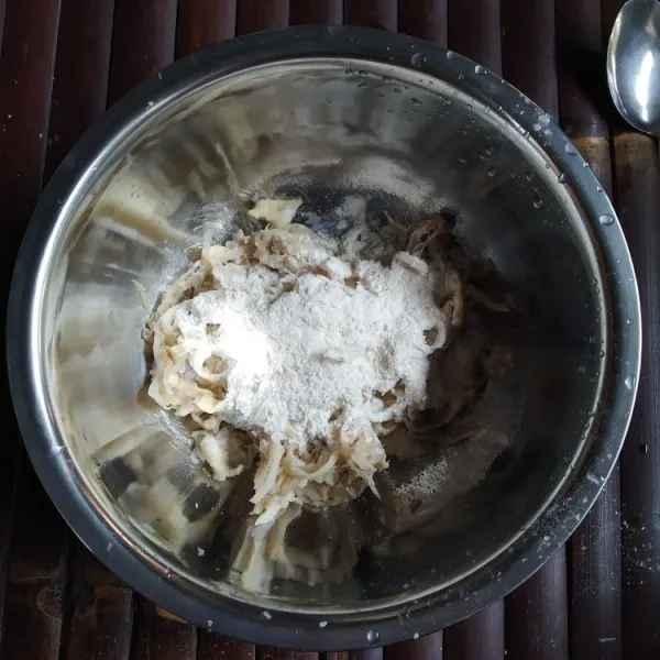 Bilas dengan air mengalir hingga bersih, kemudian peras jamur hingga benar-benar kering, tambahkan tepung terigu, sejumput garam dan merica, aduk rata.