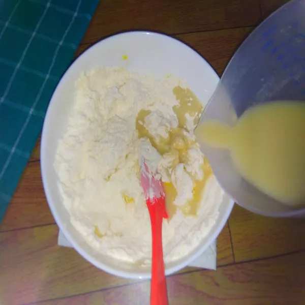 Tuang air campuran ragi ke dalam tepung terigu. Aduk rata dan uleni hingga kalis.