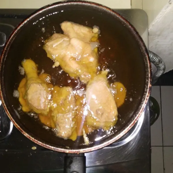 Goreng ayam dalam minyak panas sampai kuning kecoklatan.