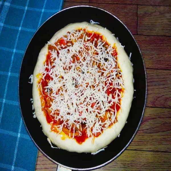 Berikan bahan isian diatas adonan dan taburi keju parut Mozarella.