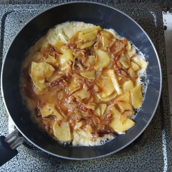 Panaskan teflon, beri sedikit minyak, masak omelet dengan api kecil