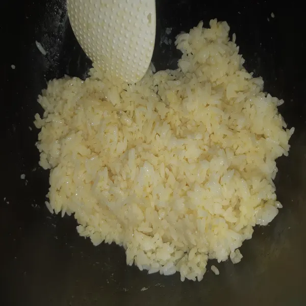 Siapkan nasi dingin (yang sudah ditaruh di kulkas semalaman), lalu pecahkan telur ke dalam nasi, aduk nasi hingga tercampur rata dengan telur.