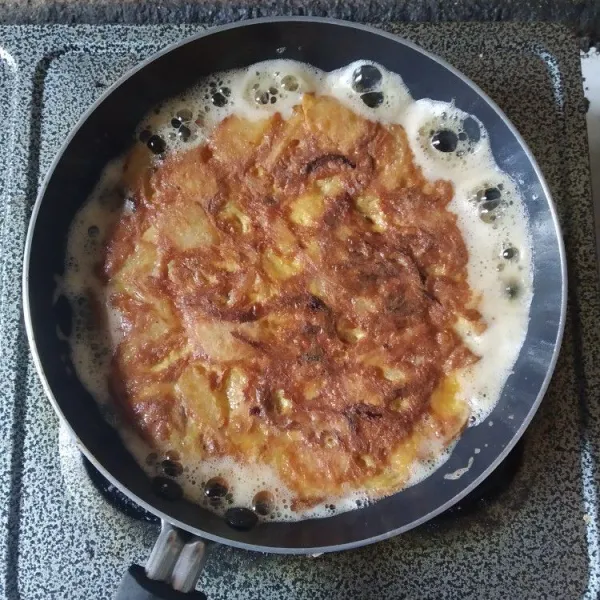 Balik omelet dan masak hingga sisi satunya matang, potong-potong, sajikan hangat