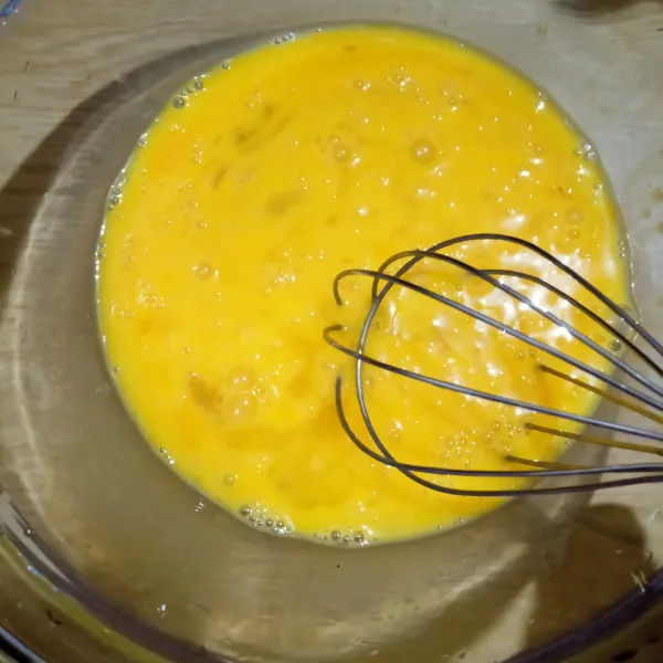 Kocok telur dan gula pasir dengan whisk hingga gula larut.