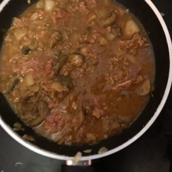 Tumis bawang putih dan bawang bombay dengan minyak. Masukkan jamur, daging, saos bolognese, garam dan lada. Masak hingga mendidih dan masukkan spaghetti, aduk rata.