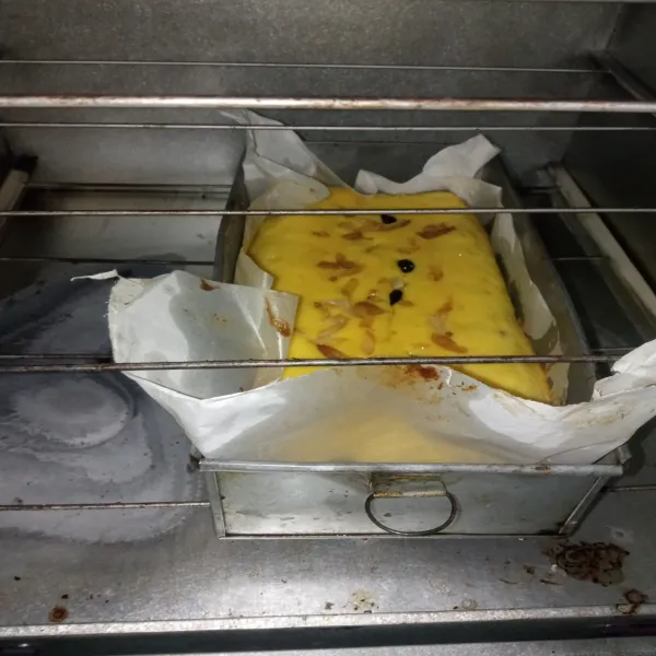 Tuang ke dalam oven ukuran 10 x 20 cm yang dilapisi dengan baking paper, yang sudah diolesi dengan mentega. Hias dengan kacang almond dan Raisin.