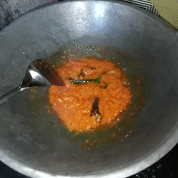 Tumis bumbu halus, serai, daun jeruk dan daun salam hingga bumbu matang.