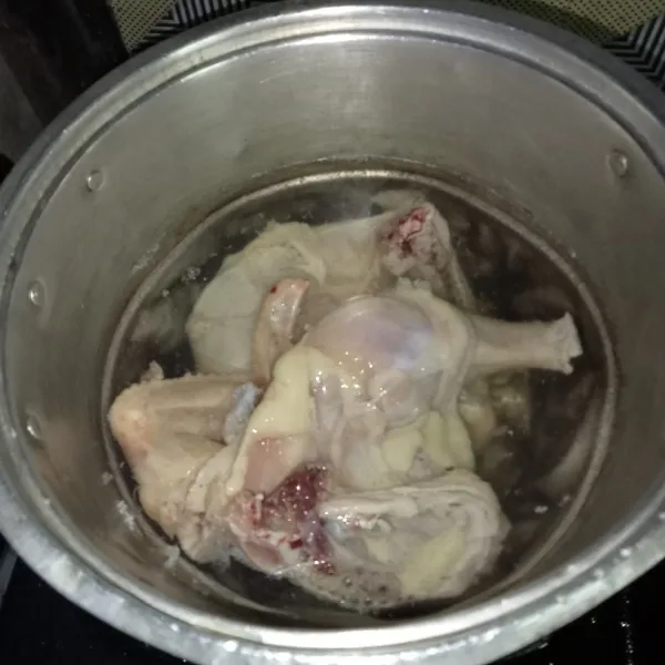 Rebus ayam di air mendidih selama 3 menit, lalu buang air rebusannya.
