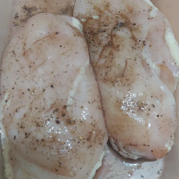 Balur daging ayam dengan garam dan lada bubuk, biarkan selama 30 menit sebelum di panggang