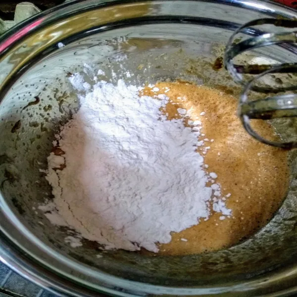 Tambahkan terigu dan baking powder sambil di ayak. Setelah merata masukkan dalam loyang yg telah diolesi minyak