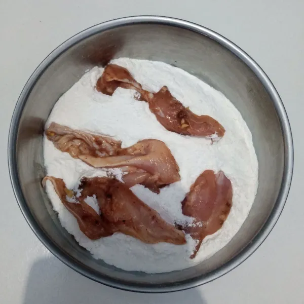 Gulingkan ayam ke dalam adonan kering.