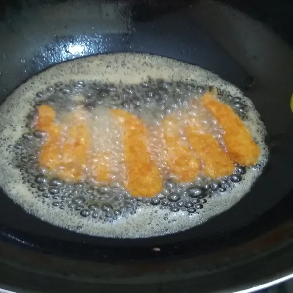 Panaskan minyak dan goreng udang tepung panir dengan api sedang sampai berwarna kuning keemasan. Lalu sajikan.