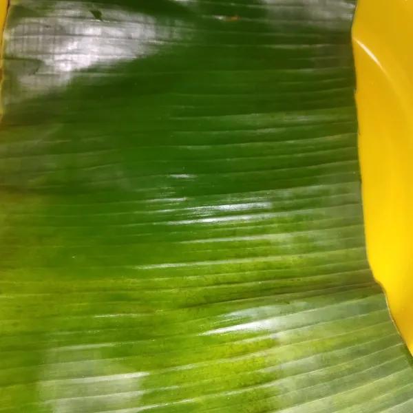 Siapkan daun pisang sebanyak 3 lembar, dengan lebar masing-masing kira-kira 2 jengkal, layu garang daun pisang diatas api kompor supaya daun layu dan tidak mudah robek saat membungkus nasi.