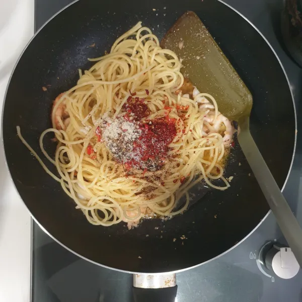 Masukkan spaghetti, chili glakes, cabai rawit merah yang dicincang halus, garam, kaldu ayam bubuk, air rebusan pasta, dan rainbow peppercorn/ blackpepper.