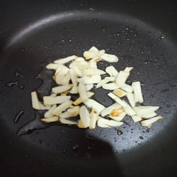 Iris 2 siung bawang putih lalu tumis hingga harum