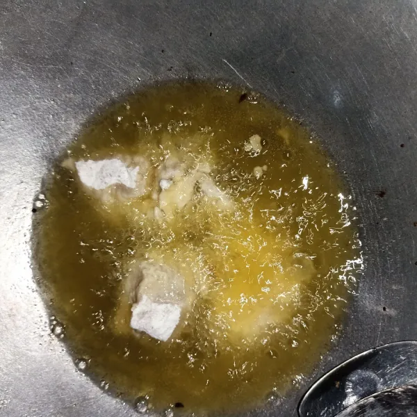 Masukkan ayam yang sudah di baluri tepung ke dalam minyak yang panas.