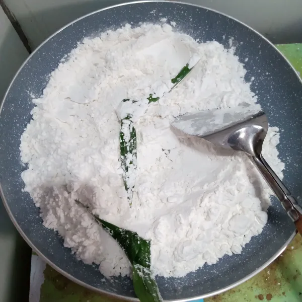Sangrai tepung sagu dan 2 lembar daun pandan selama 5 menit. Biarkan dingin