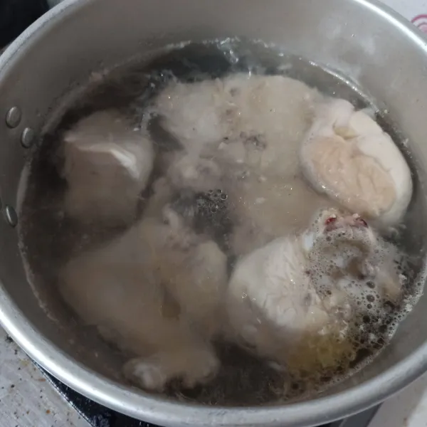Rebus ayam dan air 5 menit lalu buang airnya, ganti dengan air baru dan rebus lagi sampai ayam matang, lalu tiriskan.