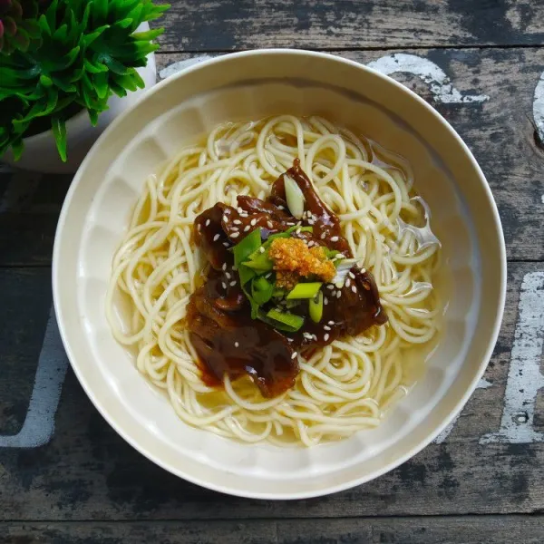 Siram mi dengan dengan kuah, beri topping daging bulgogi,  irisan daun bawang dan bawang putih goreng, sajikan hangat.