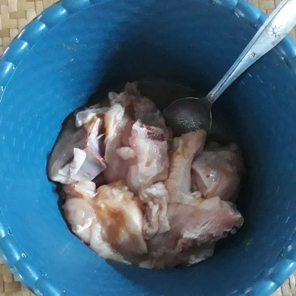 Lumuri ayam dengan bawang putih, kunyit bubuk, dan garam. Diamkan 10 menit agar bumbu meresap.