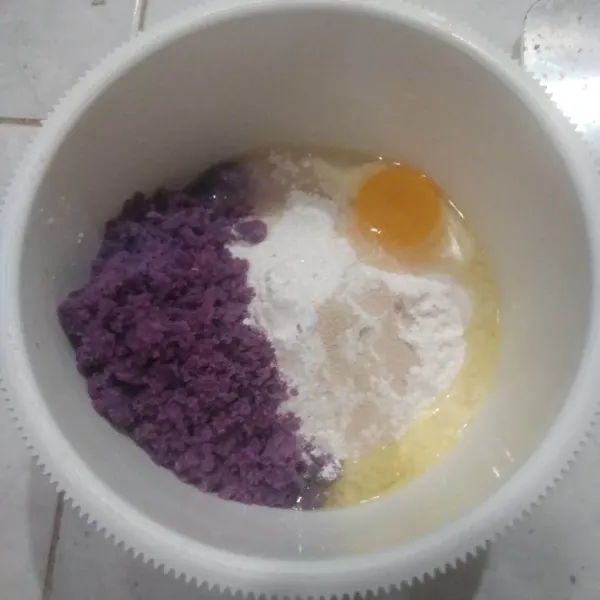 Campurkan tepung terigu, gula pasir, telur, ubi ungu, susu bubuk, ragi instan, dan susu cair. Aduk rata.