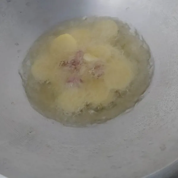 Kupas kentang, cuci bersih. Kemudian potong tipis (±½cm). Lalu goreng hingga matang (empuk), dan pada gorengan pertama goreng bersama bawang merah dan bawang putih. Tiriskan.