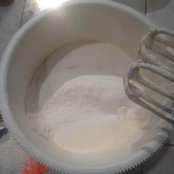 Tambahkan tepung terigu yang sudah diayak bersama susu bubuk dan baking powder. Mixer rata dengan kecepatan rendah.