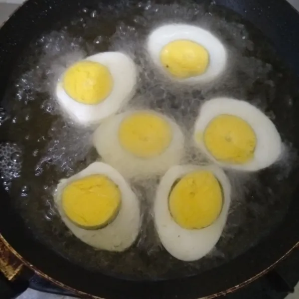 Belah telur yang sudah direbus, lalu goreng sampai berkulit