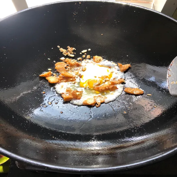 Masukkan satu butir telur ayam lalu tumis hingga harum.