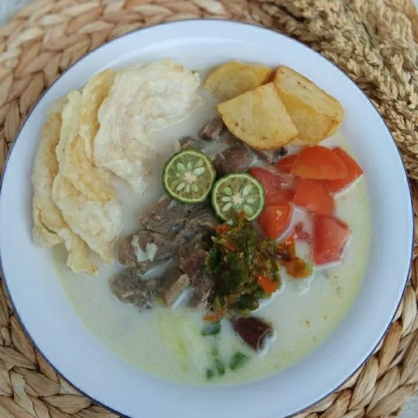 Siapkan mangkuk saji, tuang soto ke dalam mangkuk beri pelengkap kentang goreng, irisan tomat, emping goreng. sambil rawit dan perasan jeruk limau