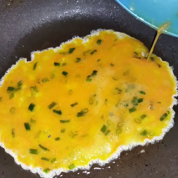 Panaskan wajan, lalu oles wajan minyak goreng / margarin. Jika wajan sudah panas, dadar telur dengan api sedang cenderung kecil.
