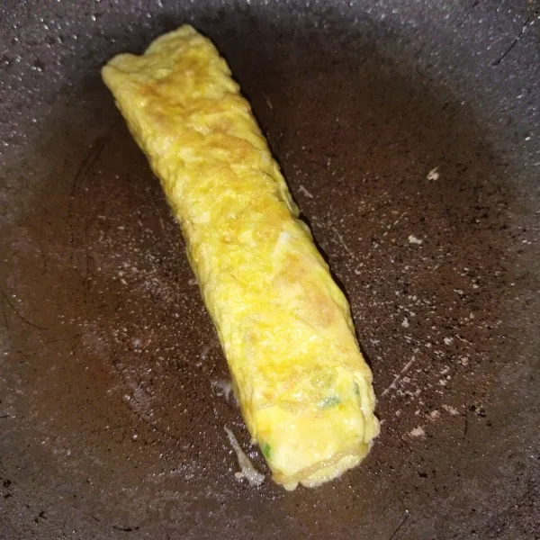 Gulung telur dadar, lalu masak dibolak balik hingga semua sisi telur matang, angkat lalu buat langkah yang sama untuk telur dadar yang satunya lagi.