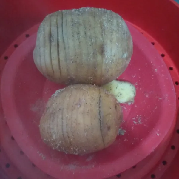 Cuci bersih kentang di air mengalir sampai bersih, lalu iris tipis jangan putus. setelah itu olesi dengan garam dan lada. Kukus 25 menit