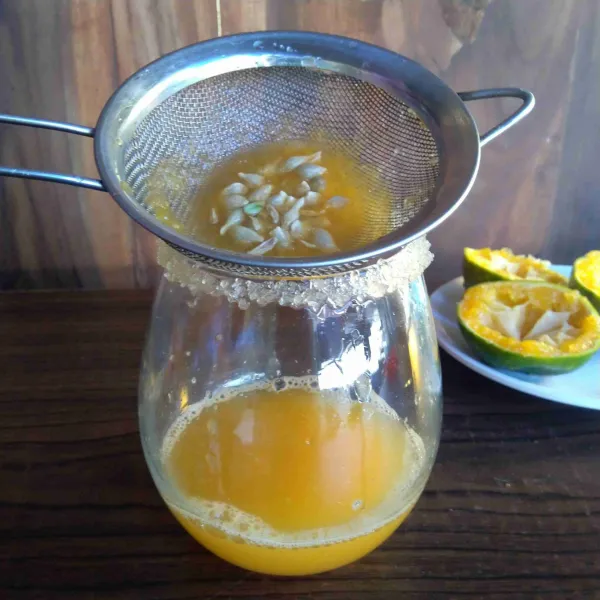 Perah jeruk, saring dan masukkan sari jeruk ke dalam gelas.