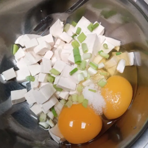Potong kotak kecil-kecil tahu. Campur dengan telur, garam, dan daun bawang.