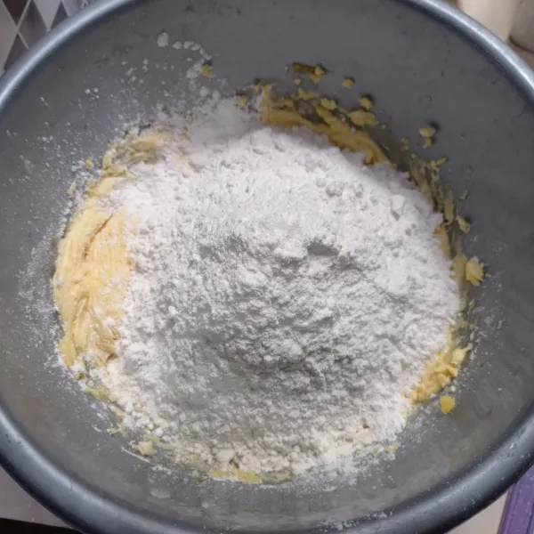 Ayak tepung terigu, maizena dan susu bubuk. Kemudian masukan kecampuran margarin aduk rata menggunakan spatula sampai kalis.