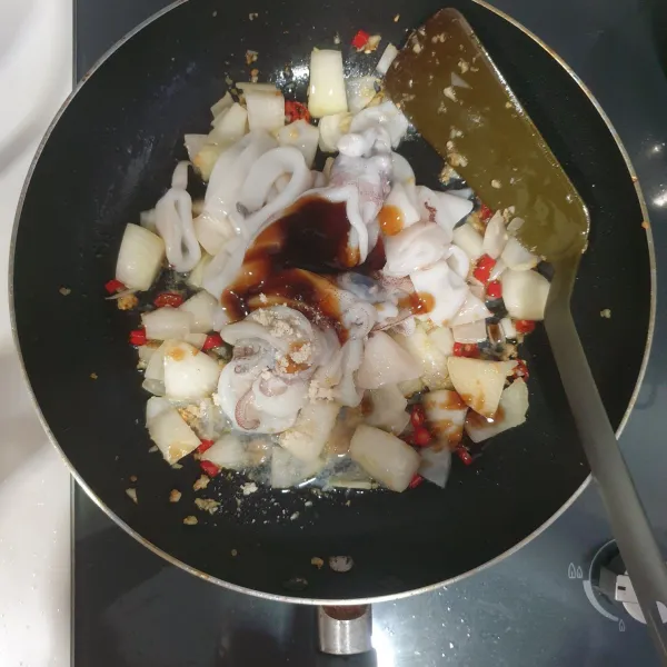 Masukkan cumi-cumi yang telah dibersihkan dan dipotong bulat-bulat. Masukkan saus tiram, kecap ikan thailand, dan kaldu jamur.