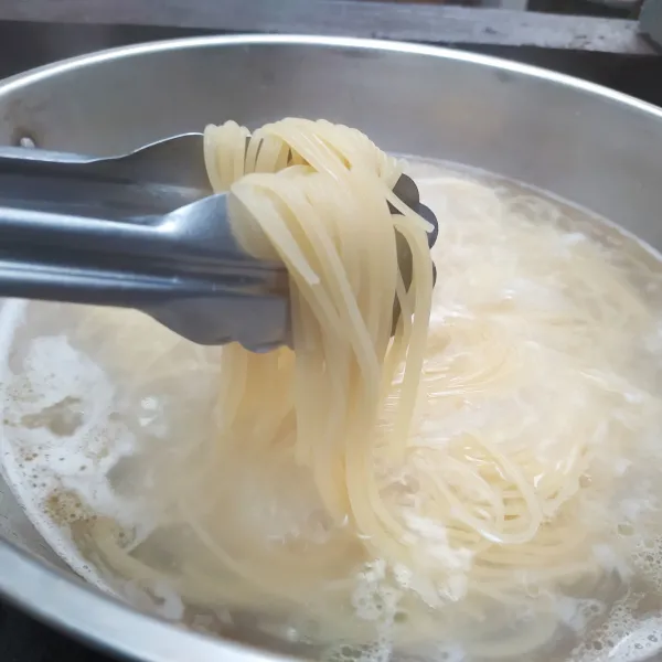 Rebus spaghetti pasta bersama sedikit garam dan minyak hingga al dente, lalu tiriskan