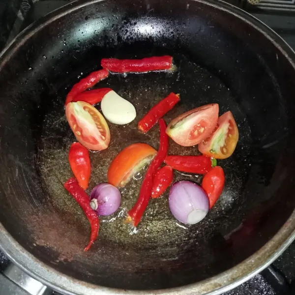 Goreng cabai, bawang merah, bawang putih dan tomat hingga layu.