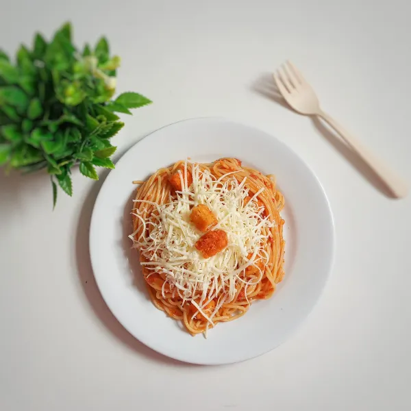 Pindahkan ke piring saji, tambahkan keju parut di atasnya.