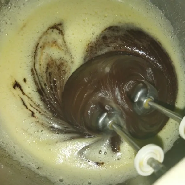 Lalu masukkan cokelat yang tadi sudah dilelehkan, mixer dengan kecepatan rendah hingga tercampur rata.