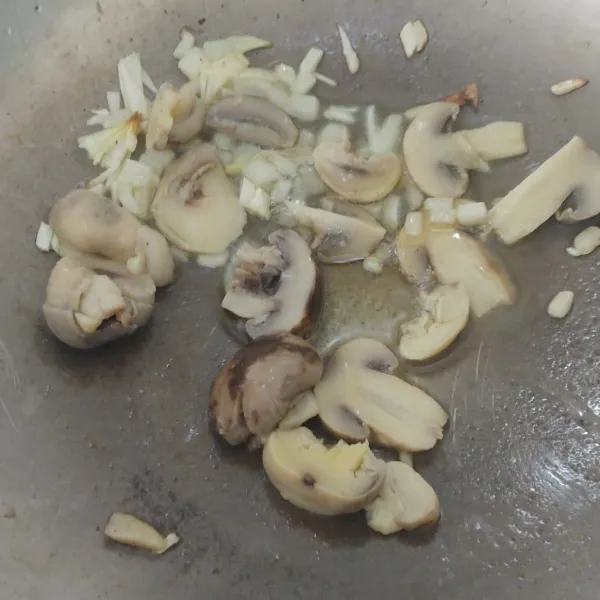 Tumis bawang bombay dengan margarin sampai harun dan layu, masukan potong jamur kancing, aduk rata