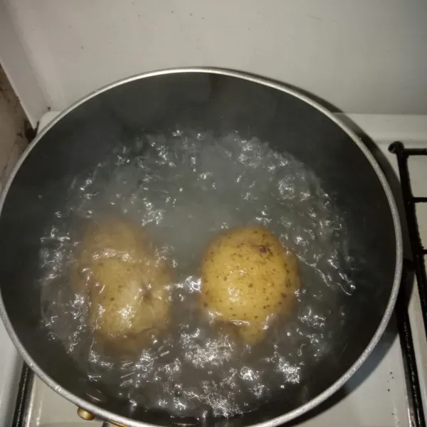 Rebus kentang, setelah empuk, kupas dan potong-potong.