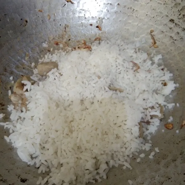 Masukan nasi putih, masak hingga nasi panas merata.