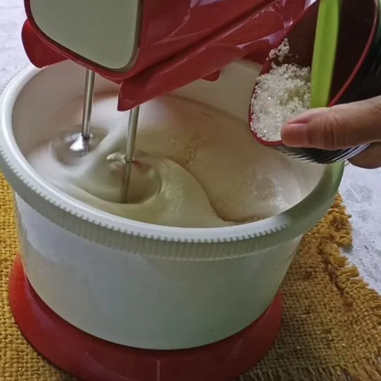 Mixer putih telur dan garam dan air jeruk nipis hingga berbusa. Lalu masukkan gula pasir bertahap sebanyak 3x. Mixer hingga soft peak.