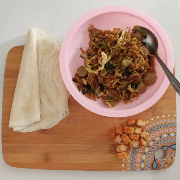 Potong kecil-kecil chicken stik, masukkan ke dalam mie, aduk rata.