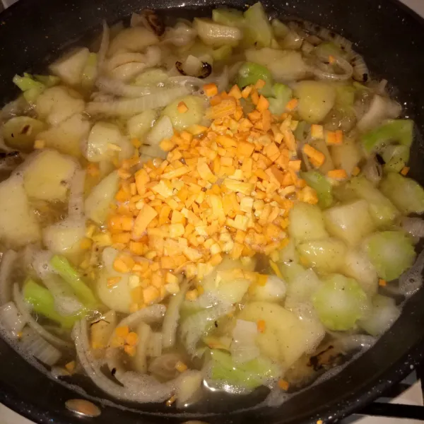Masukkan batang brokoli rebus dan kentang, lalu tambahkan wortel. Masak sebentar.